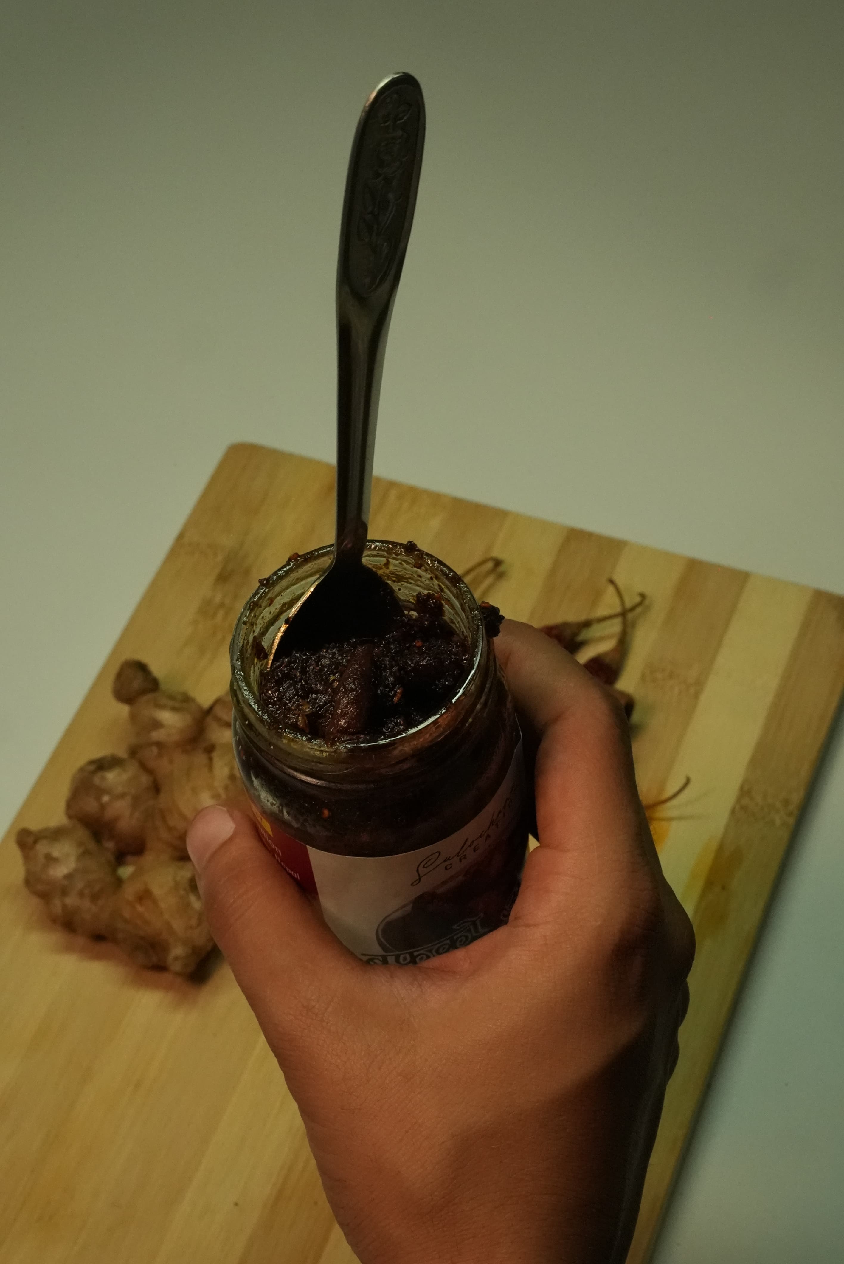 Hand scooping fresh achar from jar